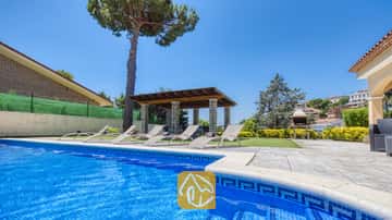 Privé-buitenzwembad bij Villa Paris met blauw getegelde randen, diverse ligstoelen op het terras, een overdekte pergola en een stenen barbecue op de achtergrond.