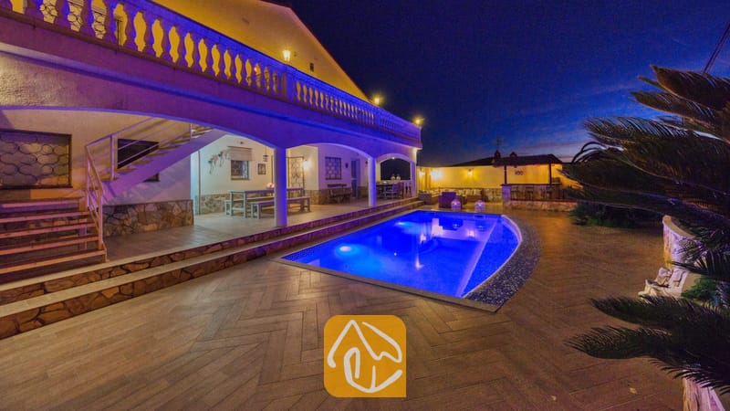 Verlicht zwembad en terras van Villa Madonna bij nacht, met buitenverlichting, een overdekte veranda en zitgelegenheid buiten.